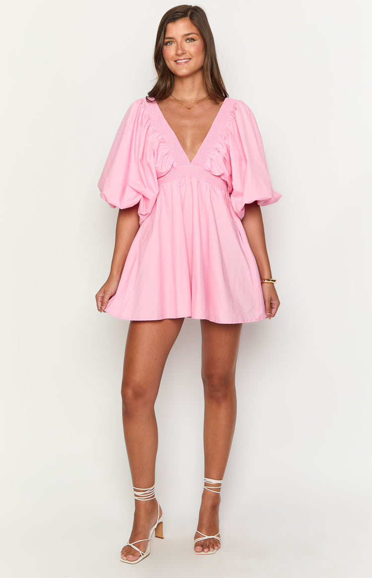 Pink mini dress with a deep V-neck, smocked bodice, voluminous short puff sleeves, and a gathered A-line mini skirt