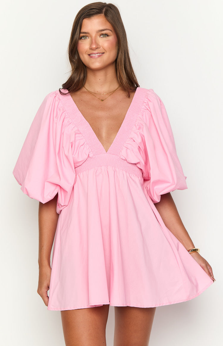 Pink mini dress with a deep V-neckline, smocked detail on the bodice, and voluminous puff short sleeves