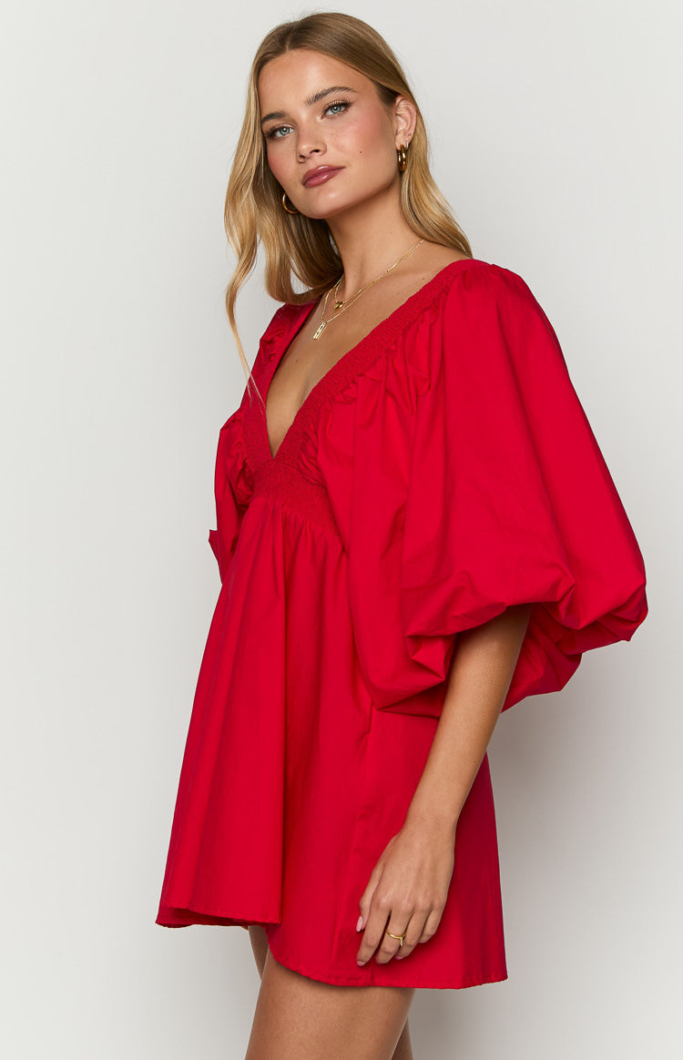 Side view of a red mini dress with a deep V-neck, smocked bodice, and voluminous short puff sleeves