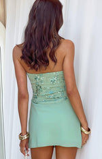 Rear view of a green strapless mini dress with an intricately beaded and sequined floral bodice