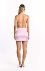 Rear view of a light pink satin mini dress featuring a low open back with thin horizontal straps