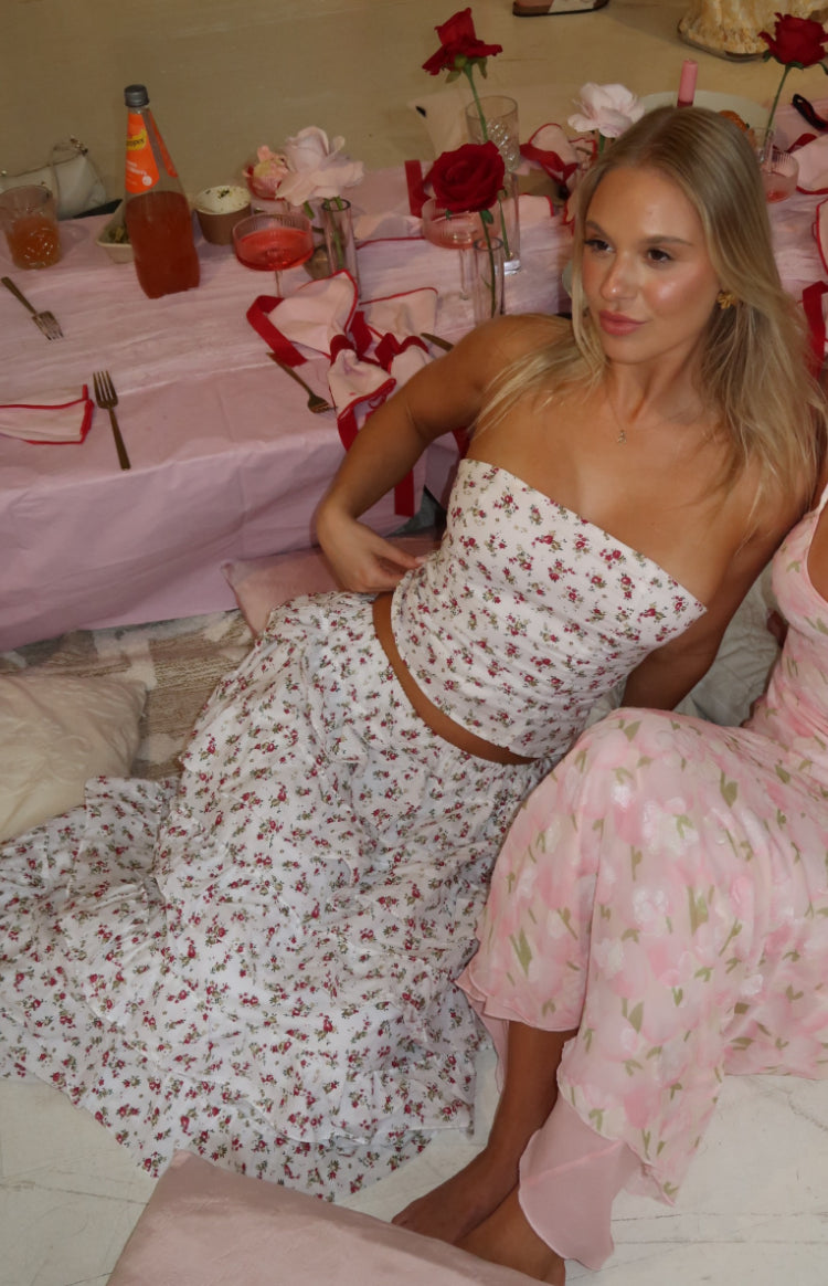 Fitted white strapless bandeau top with small red floral print, cropped at the waist