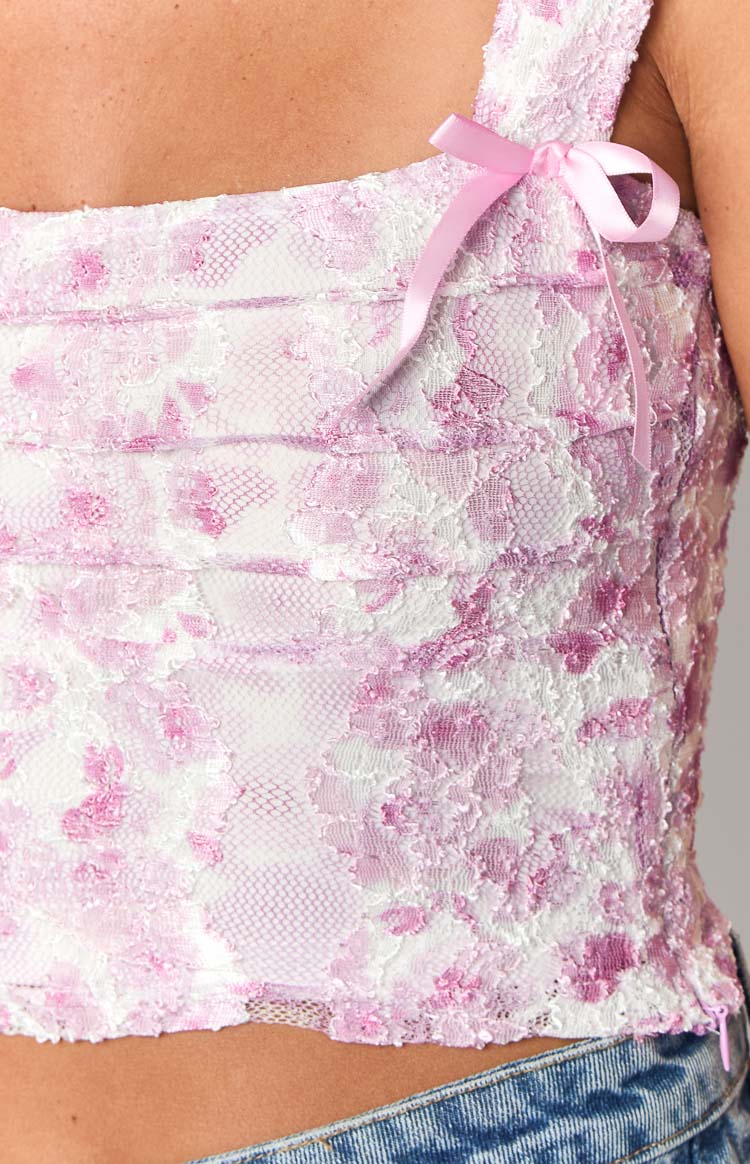 Detail shot of the pink lace top showing the floral pattern and a small pink satin bow on the strap