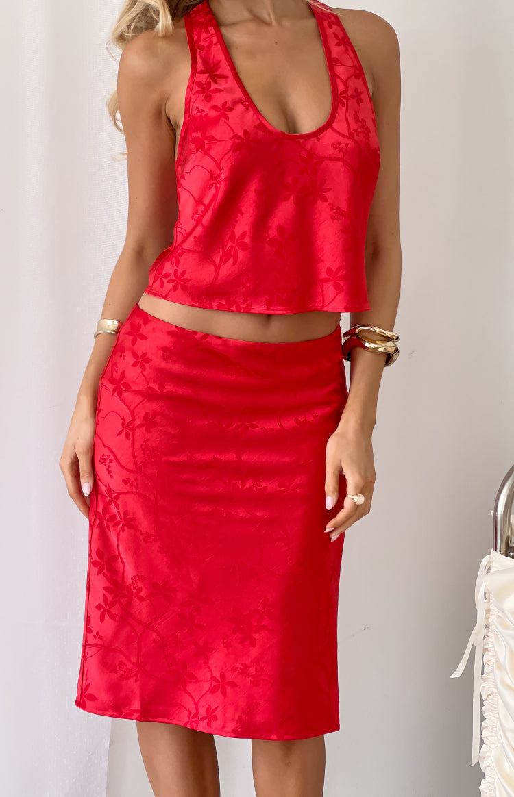 Close-up of the red floral print satin midi skirt showing the fitted waist and subtle floral pattern