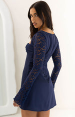 Side view of a navy mini dress showing the sheer floral lace long sleeves and fitted bodice