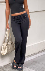 Black low waist pants with a button-front waistband and a straight leg featuring a subtle ankle slit