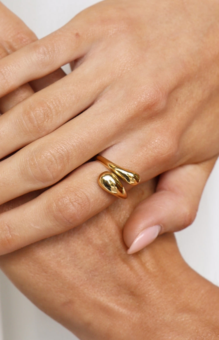 Close-up of the gold adjustable wrap ring with two prominent smooth teardrop shapes