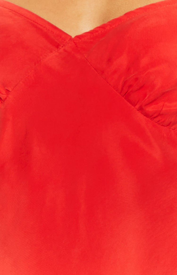 Close-up of the red V-neckline and gathered bust detail of the mini dress