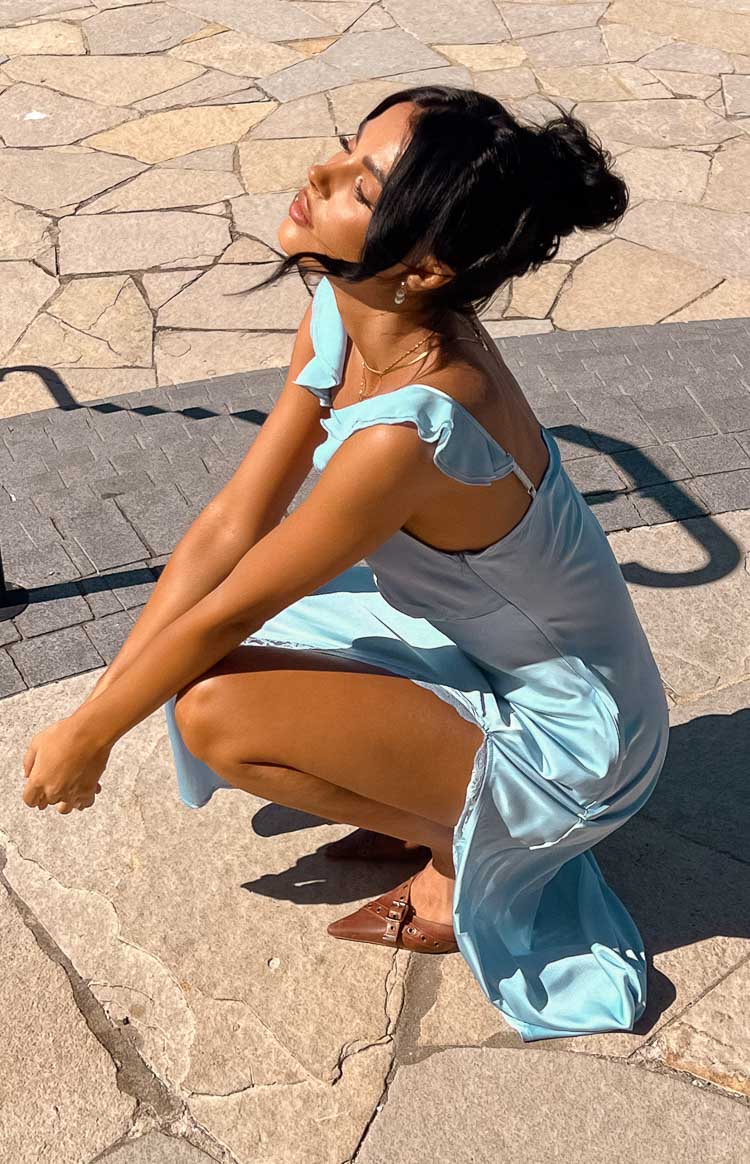 Side profile of a light blue maxi dress with ruffled shoulder straps and a ruched side seam