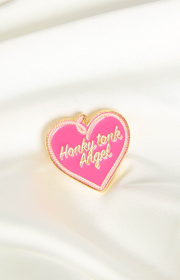 Pink heart-shaped pin with gold rope-style trim and "Honky tonk Angel" text