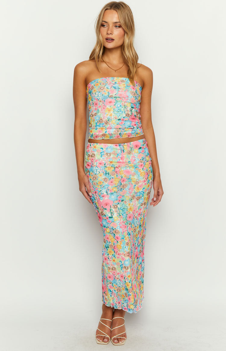 Full-length view of a multi floral print strapless crop top and fitted maxi skirt with lettuce hems