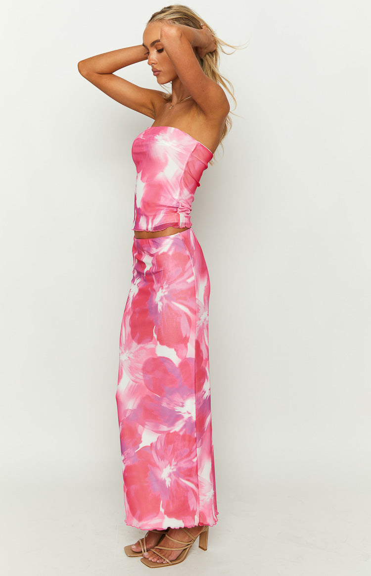 Side view of a pink floral print mesh maxi skirt with a fitted silhouette and lettuce hem
