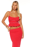 Girl showing the back of the Wiatt Red Top highlighting the comfortable shirred panel a perfect choice for a date night.