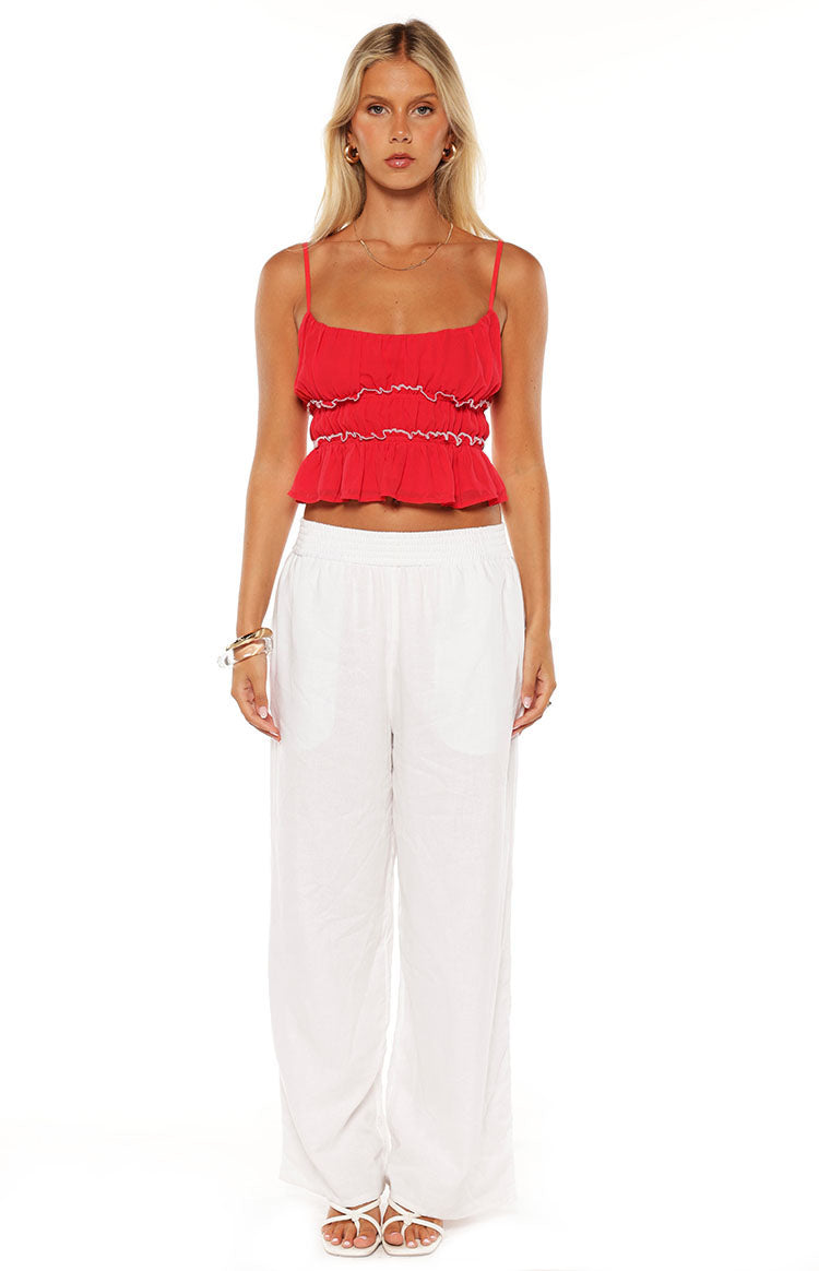 Red cropped top with square neckline, thin spaghetti straps, and tiered ruffles with white trim
