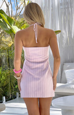 Rear view of a pink and white stripe halter neck mini dress with a tie-back detail