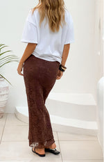Rear view of a brown lace midi skirt with a fitted silhouette and slight flare at the hem