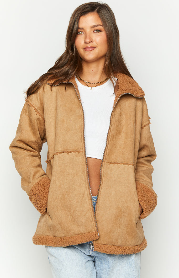 Front view of a brown suede jacket with an open zipper, showing fur lining on the collar, cuffs, hem, and exposed seam details
