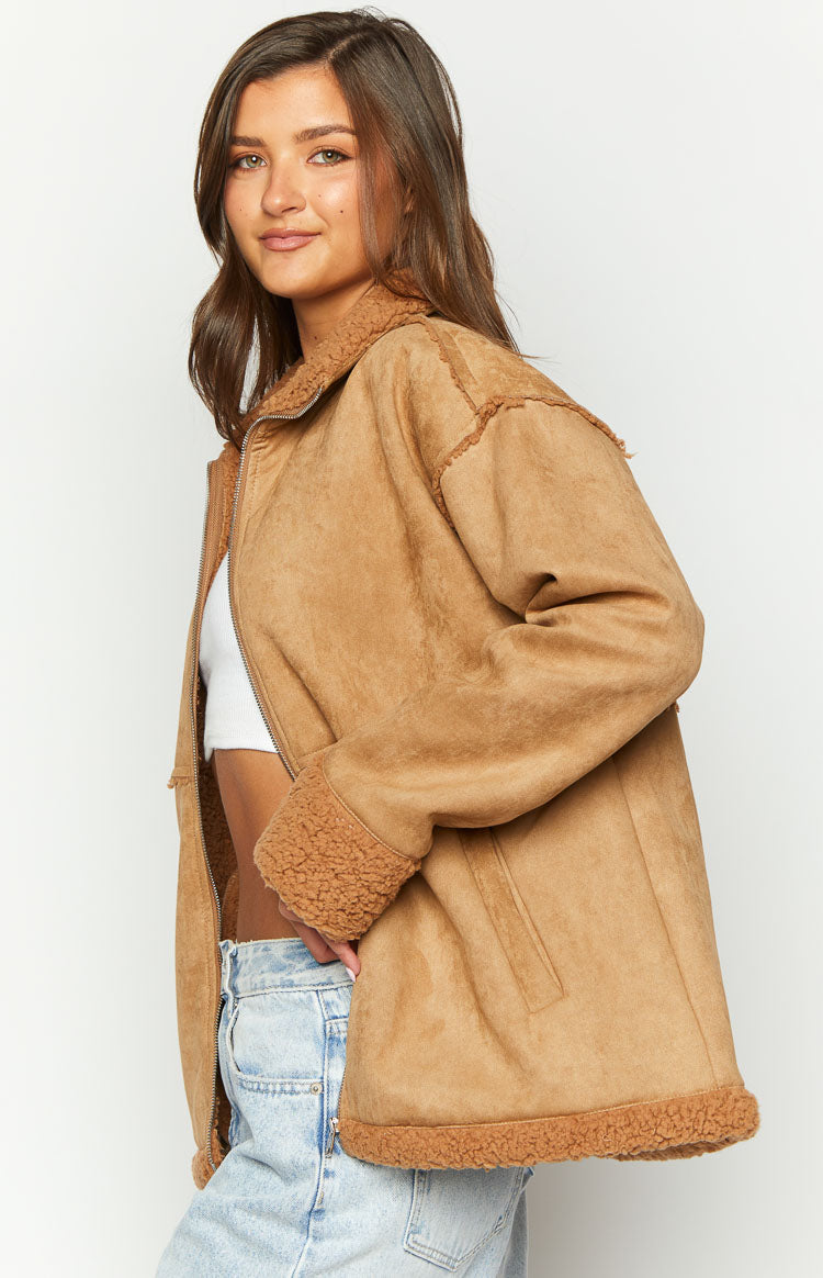 Side view of a brown suede fur jacket, unzipped to reveal the inner fur lining, with fur trim on the collar, cuffs, and hem