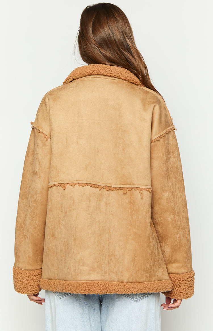 Back view of a brown suede jacket showing the fur collar, fur-trimmed hem, and cuffs