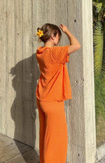 Side view of orange wide-leg knit pants with a textured diamond pattern and relaxed fit
