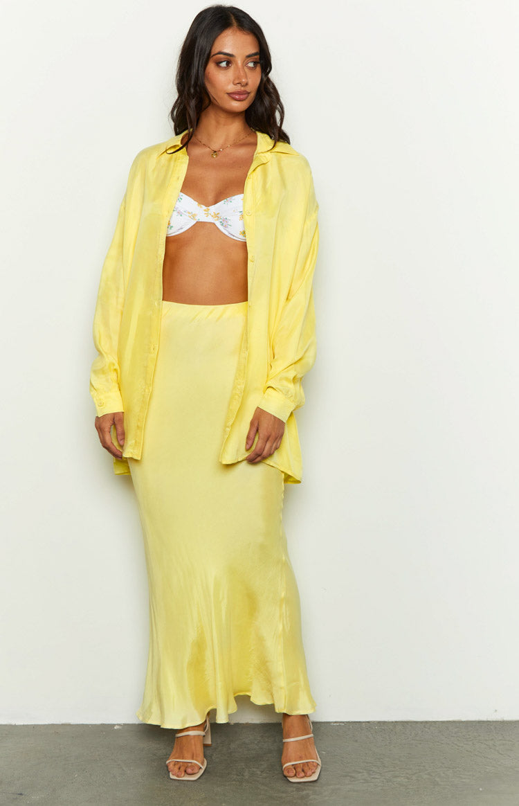 Full length view of a yellow cupro button-up shirt with long sleeves and a relaxed fit