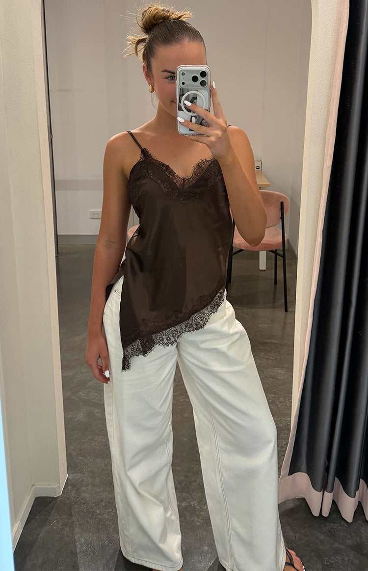 Brown satin asymmetrical top with V-neckline and lace trim along the neck and hem