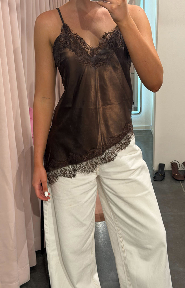 Brown satin top with a V-neckline and lace trim, showing the asymmetrical hemline with lace detail