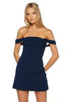 Model in a navy blue crepe off the shoulder mini dress with an a line fit perfect for a semi formal event or homecoming