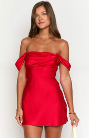 Draped off-the-shoulder neckline of a red satin mini dress with a fitted bodice