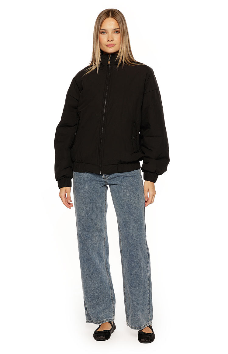 Oversized black puffer jacket featuring a high stand collar, full zip, and elasticated cuffs and hem