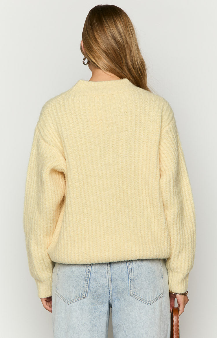Back view of the yellow oversized sweater, showing the vertical ribbed knit texture and relaxed fit with long sleeves