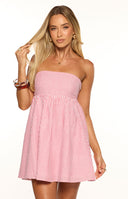 A close up shot of our model wearing a strapless mini dress with thin vertical red and white stripes. This dress has a fitted bodice and a high gathered waist that flows into a voluminous flared skirt.