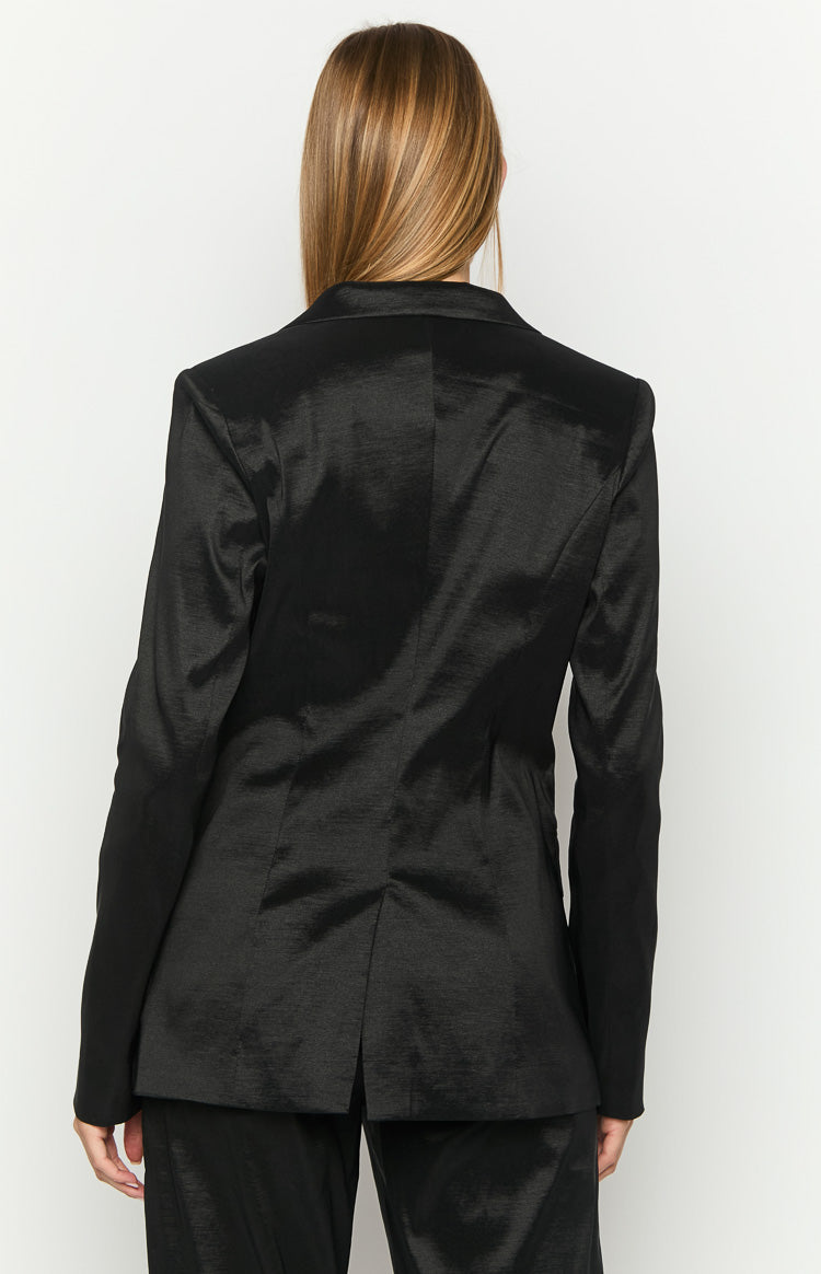 Rear view of a black blazer with a subtle textured fabric and a single back vent