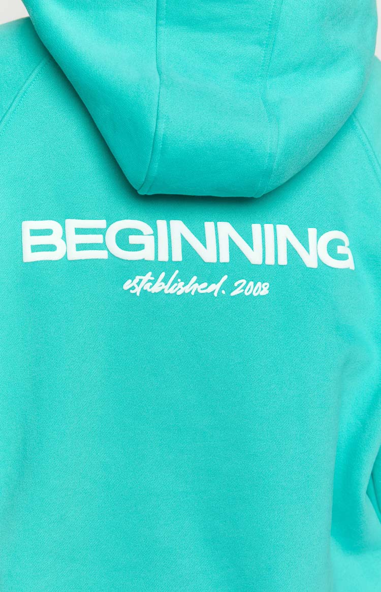 Detail shot of the white 'BEGINNING established. 2008' print on the teal hoodie's back