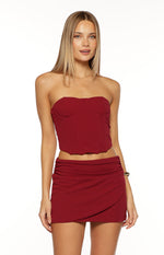 Burgundy wrap mini skirt featuring a ruched left side and an asymmetrical overlapping front hem