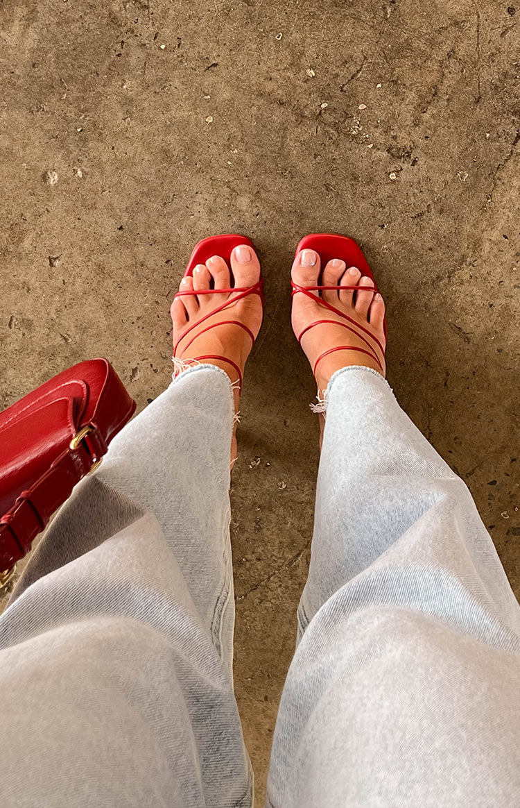 Overhead view of strawberry red square toe heels with thin criss-cross straps across the foot