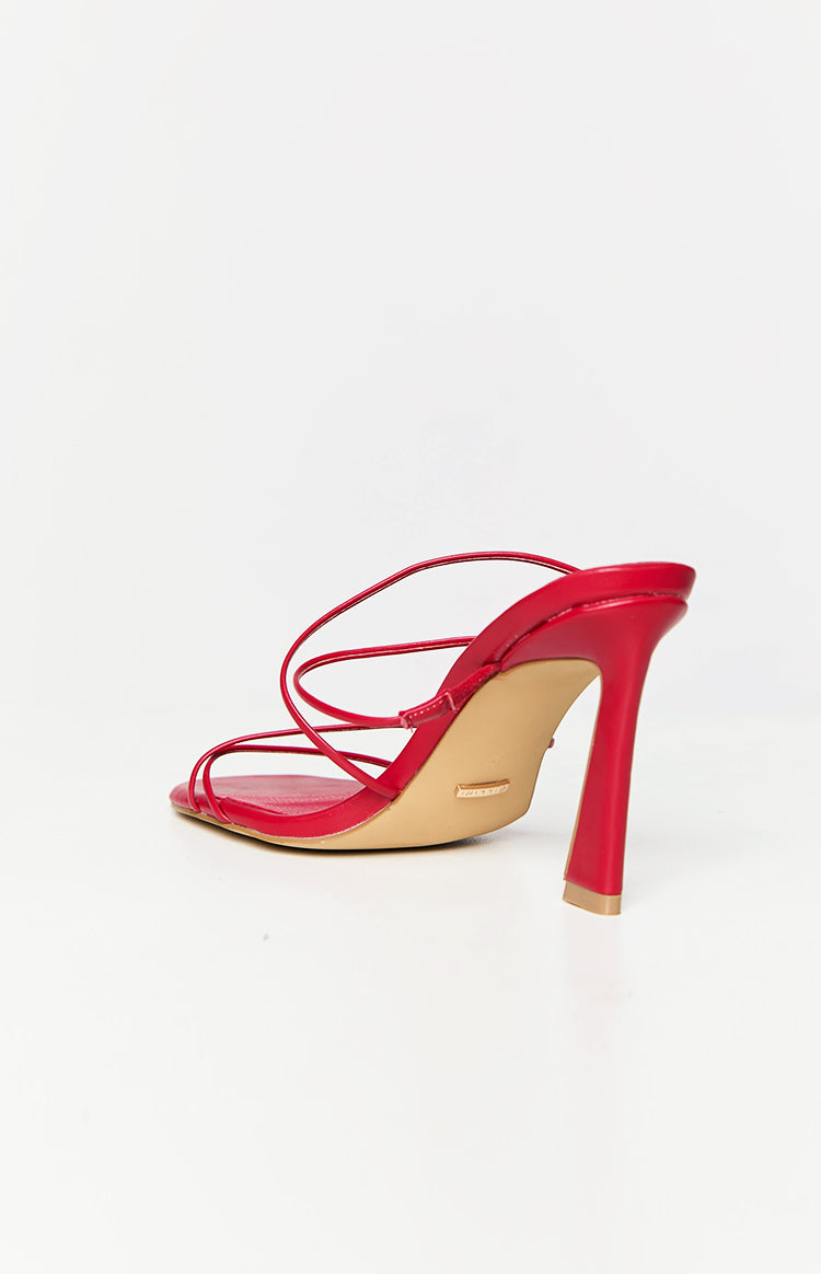 Side-rear view of red square-toe mule heels with thin criss-cross straps and a flared block heel