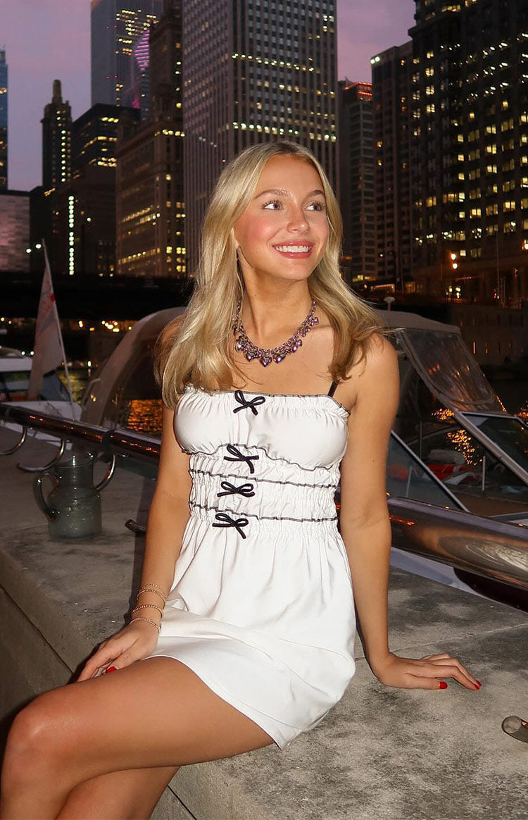 Beginning Boutique It Girl White Bow Mini Dress white bandeau mini dress with black spaghetti straps and ruched bodice with black bows