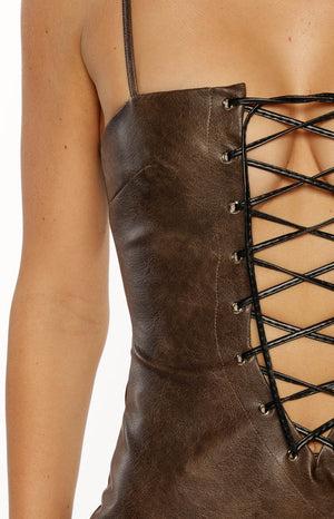 Close-up of the black criss-cross lacing and silver eyelets on the vintage brown PU mini dress bodice