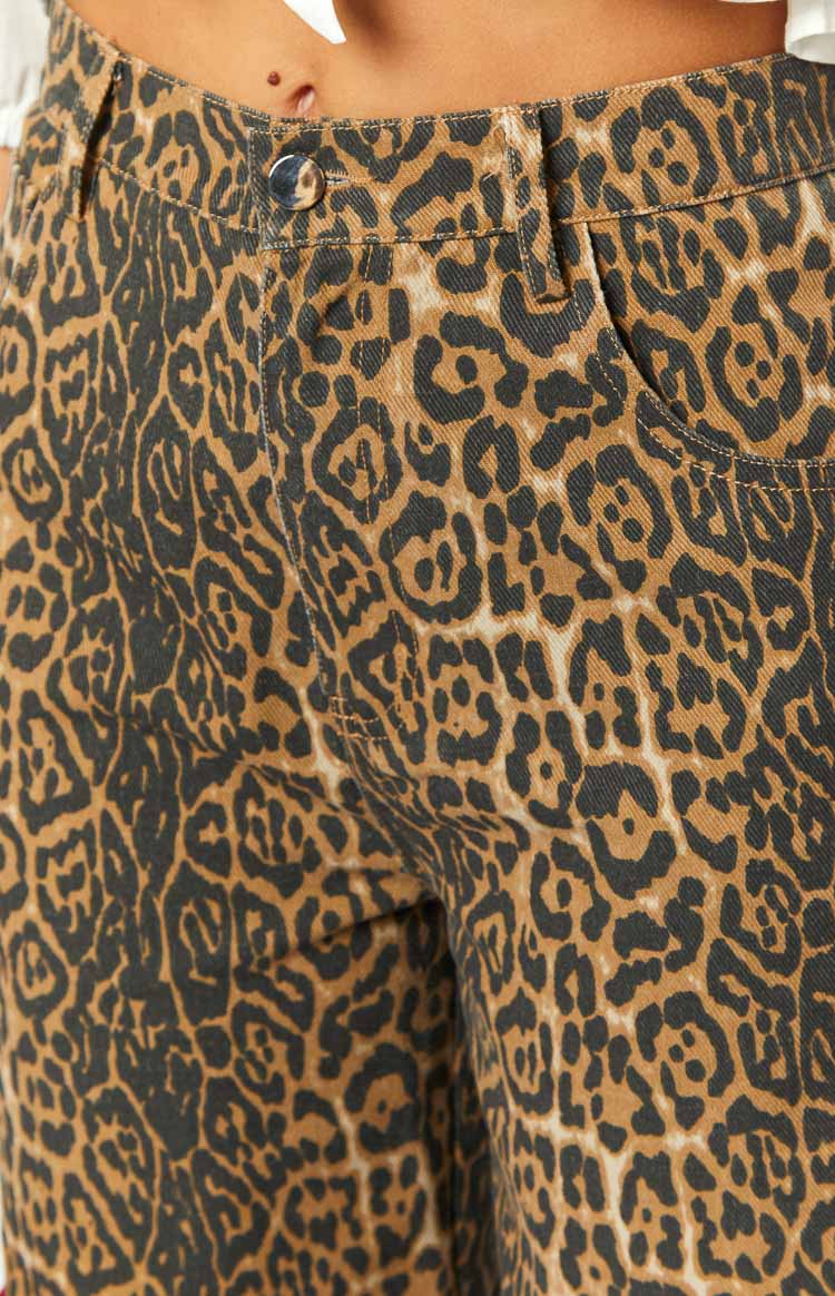 Close-up of the brunet leopard print jeans showing the front button closure, belt loops, and pocket opening