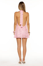 Rear view showing the tied halter neck and deep open back of a pink beaded mini dress