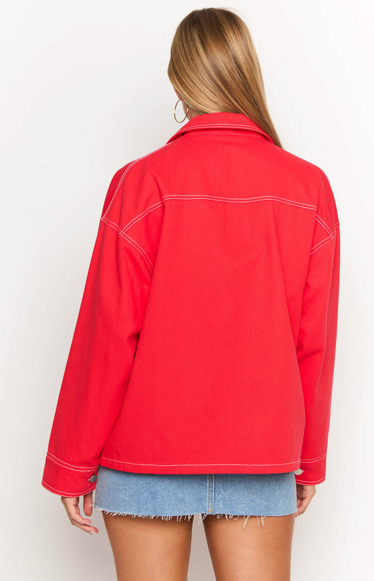 Rear view of a red denim jacket with white contrast stitching on the seams, collar, and shoulders