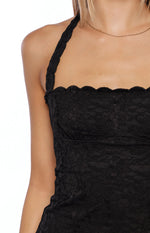 Close-up of the black lace halter neck top showing the scalloped neckline, textured lace, and halter strap