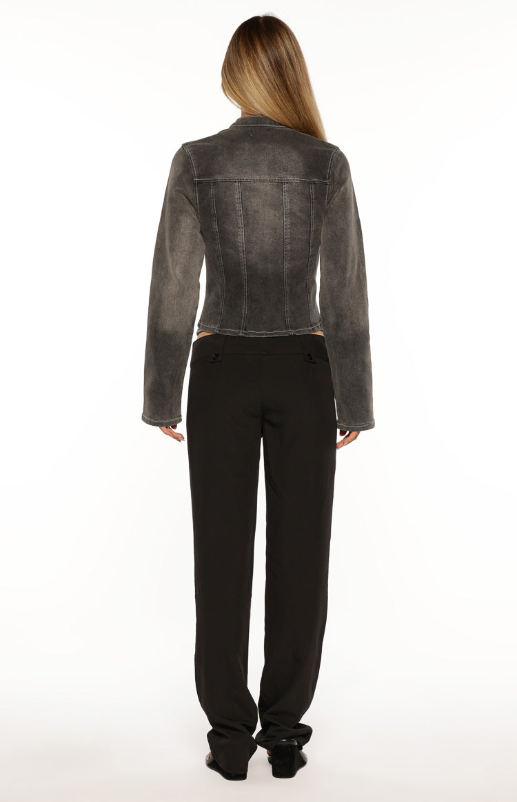 Back view of a black washed denim biker jacket with vertical seam details and a cropped hemline