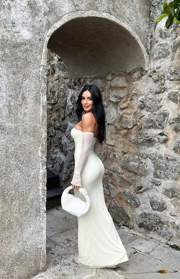 Side view of a cream strapless maxi dress with long sheer detached sleeves