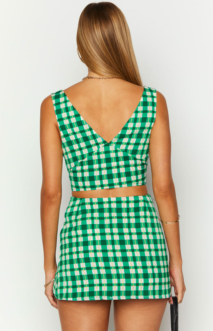 Back view of a green and cream check sleeveless crop top with a deep V-neckline