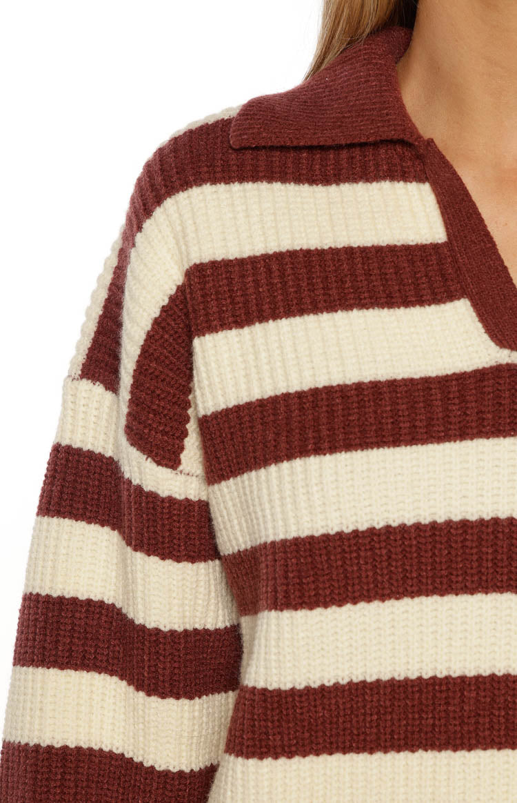 Close-up of the chunky knit texture of the burgundy and cream striped polo collar and shoulder