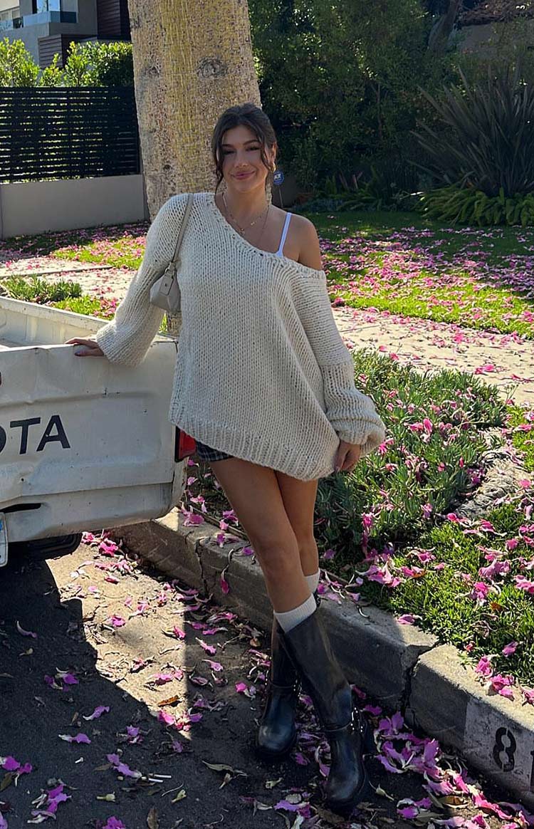 Cream chunky knit sweater with an oversized, slouchy fit, worn off one shoulder