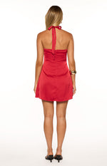 Rear view of a red satin mini dress showing the halter tie closure and exposed zipper