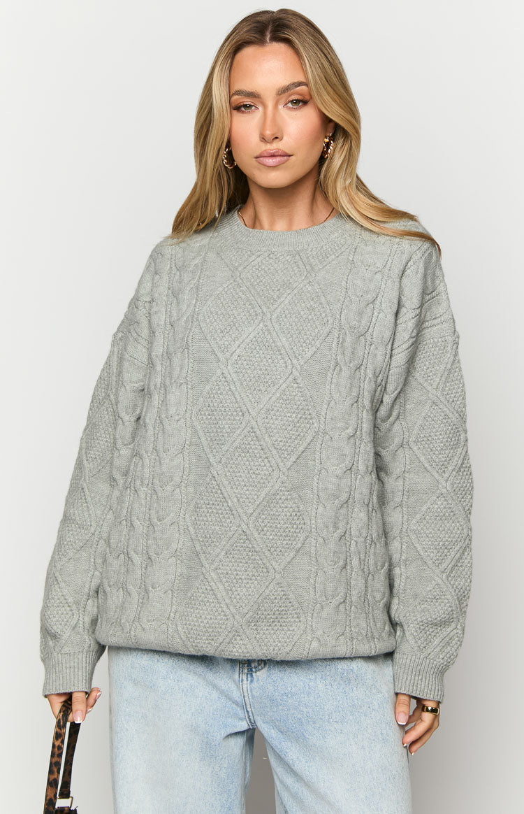 Front view of a grey cable knit sweater with a crew neck and intricate diamond and vertical cable patterns